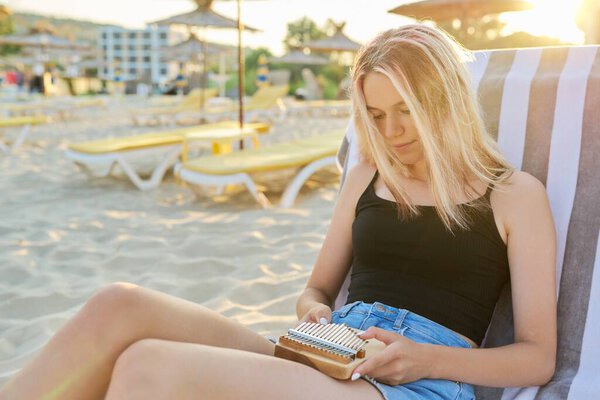 Молодая женщина держит большой палец пианино или Калимба музыкальный инструмент