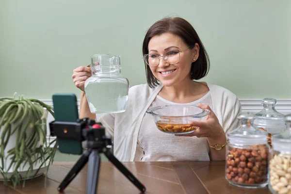 Ernährungswissenschaftler spricht über die Vorteile des Einweichens von Nüssen in Wasser, Aufzeichnung Videoblog vlog — Stockfoto