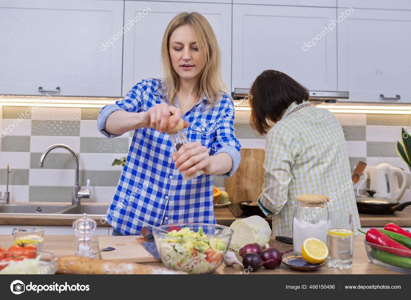 Two middle aged women cooking together at home in kitchen Stock Photo by ©Valerii_Honcharuk 466150496 photo