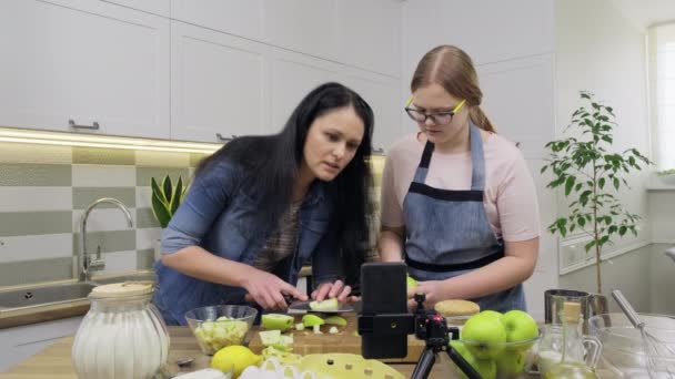 Moeder en tiener dochter koken appeltaart samen, online praten met behulp van video bellen op smartphone — Stockvideo