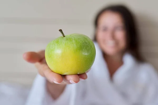 Крупный план зеленого спелого яблока в женской руке — стоковое фото