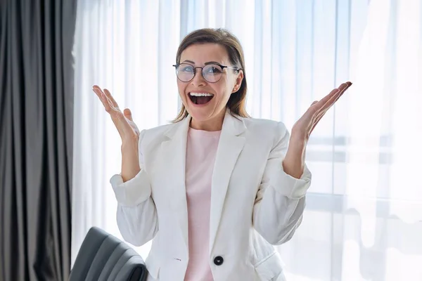 Gelukkige emotionele zakenvrouw op zoek naar camera in het kantoor — Stockfoto