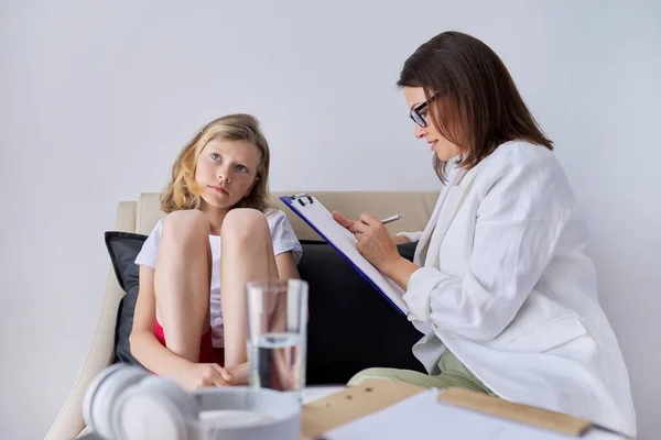 Meisje kind in sessie met vrouwelijke psycholoog counselor maatschappelijk werker in functie — Stockfoto