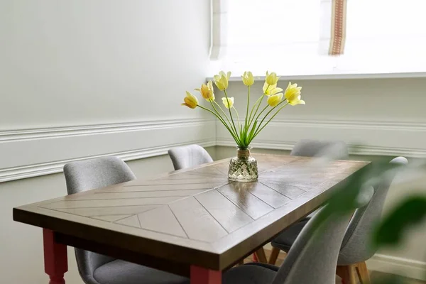 Vaso com um buquê de tulipas amarelas em uma mesa de madeira — Fotografia de Stock