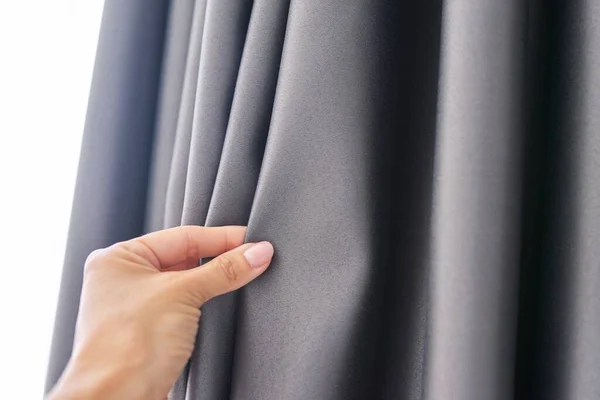 Womans mão tocando cortina, tecido blackout cinza, tecido de bloqueio de luz — Fotografia de Stock