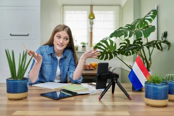 Kobieta student siedzi w domu studiuje online, patrząc na smartfona kamery — Zdjęcie stockowe