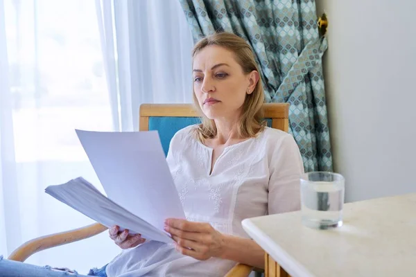 Triste emoción en la cara de la mujer madura leyendo carta de papel, contrato, documento. —  Fotos de Stock