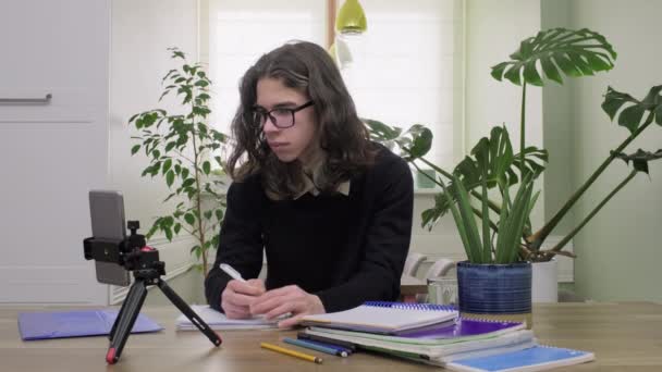 Férfi tizenéves középiskolás diák otthon nézi okostelefon kamera, tanul online — Stock videók