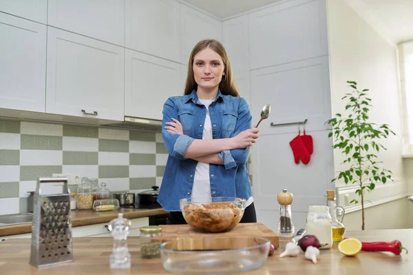 Молода жінка готує курку вдома, кухонний інтер'єр фону — стокове фото