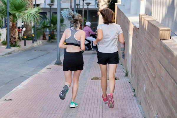 Running mother and teenage daughter, back view — Stock Photo, Image