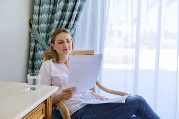 Zufriedene lächelnde Frau mittleren Alters liest Papierbrief — Stockfoto