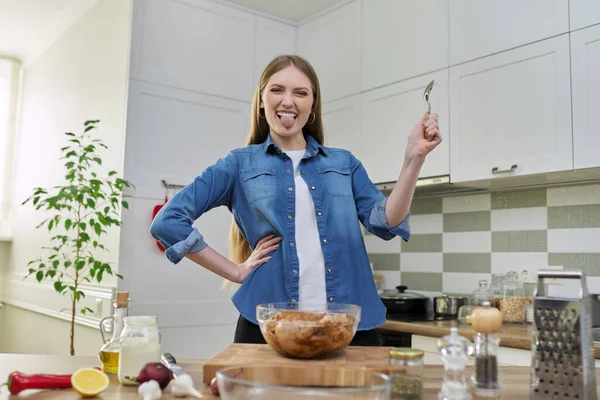 Giovane donna prepara pollo a casa, cucina sfondo interno — Foto Stock
