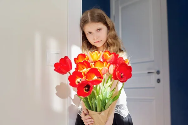 Mothers day, girl child with bouquet of red tulips flowers at home — Stock Photo, Image