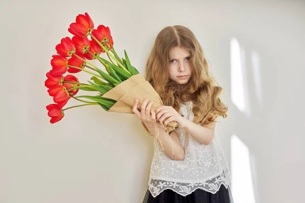 Beautiful little girl child with bouquet of red tulips — Stock Photo, Image