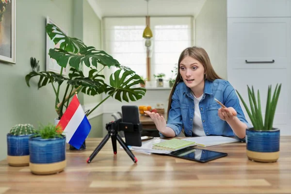 Ženské studentky sedí doma a studují online, dívají se na smartphone webcam — Stock fotografie