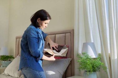 İç kumaş örnekleri olan bir kadın döşeme için kumaş ve perde seçiyor.