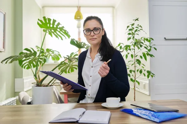 Affärskvinna tittar på kameran prata, hålla papper dokument i händerna — Stockfoto