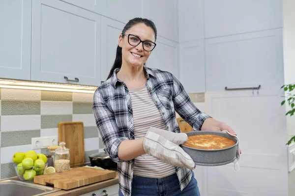 Le kvinna i köket vantar med varm nybakad paj — Stockfoto