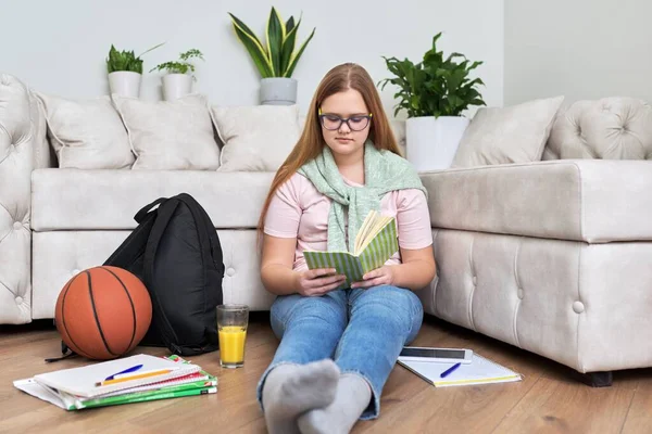 Εφηβικό κορίτσι που κάθεται στο σπίτι στο πάτωμα του σαλονιού διαβάζοντας το βιβλίο — Φωτογραφία Αρχείου