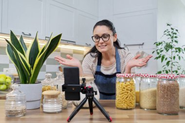 Çevrimiçi yayın, yemek hakkında blog, gevrek kavanozlu önlüklü kadın.