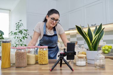 Çevrimiçi yayın, yemek hakkında blog, gevrek kavanozlu önlüklü kadın.