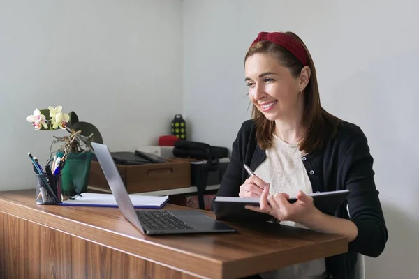 Businesswoman, female teacher working online at home with laptop using video call