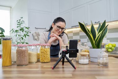 Çevrimiçi yayın, yemek hakkında blog, gevrek kavanozlu önlüklü kadın.