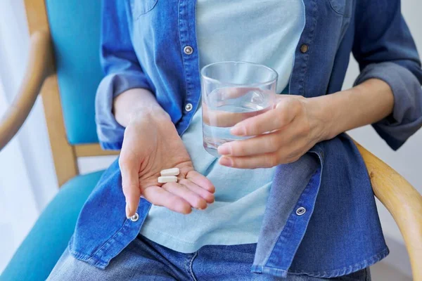 성숙 한 여성들을 가까이 서 약 과 물 한 잔을 들고 있는 모습 — 스톡 사진