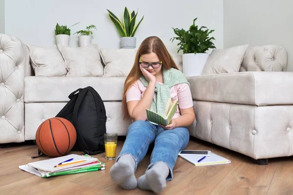 Εφηβικό κορίτσι που κάθεται στο σπίτι στο πάτωμα του σαλονιού διαβάζοντας το βιβλίο — Φωτογραφία Αρχείου