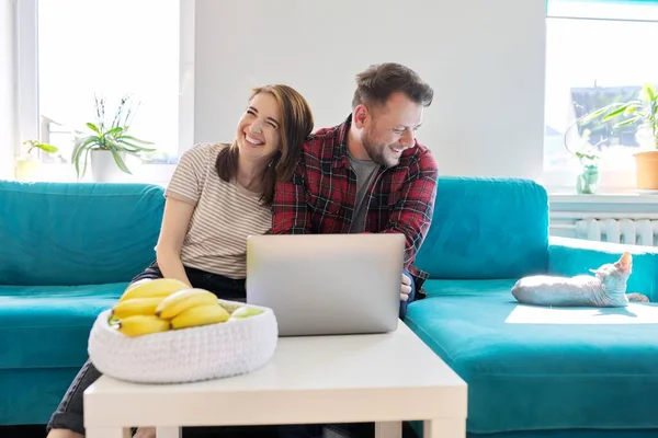 Sorrindo rindo casal positivo 40 anos, marido e mulher olhando para laptop — Fotografia de Stock