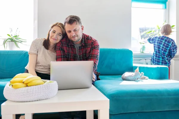 Sorrindo rindo casal positivo 40 anos, marido e mulher olhando para laptop — Fotografia de Stock