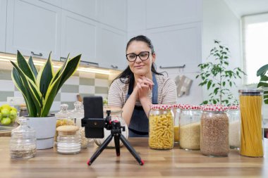 Çevrimiçi yayın, yemek hakkında blog, gevrek kavanozlu önlüklü kadın.