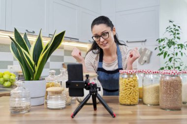 Çevrimiçi yayın, yemek hakkında blog, gevrek kavanozlu önlüklü kadın.