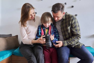 Evde mutlu bir aile, anne ve babasıyla fotoğraf makinesi olan küçük bir oğul.