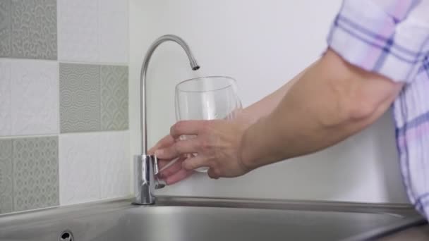 Close-up of hand with glass taking tap purified filtered water from special kitchen mixer — Stock Video