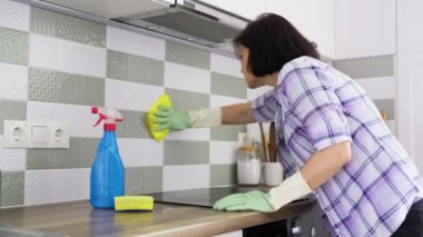 Mutfak temizliği, seramik duvar kiremitlerini yıkayan kadın ve cam elektrikli hob.