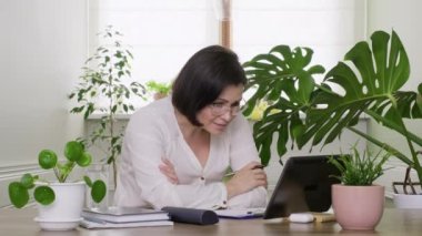 Kadın öğretmen, akıl hocası, psikolog tablet web kamerasına bakıyor, konuşuyor, danışmanlık yapıyor.