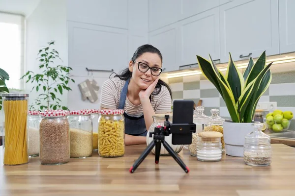 Online broadcast, blog about food, woman in an apron with jars of cereals