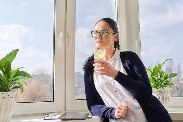 Zakelijke vrouw met glas water met citroen — Stockfoto