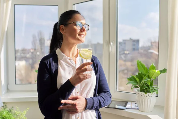 Zakelijke vrouw met glas water met citroen — Stockfoto