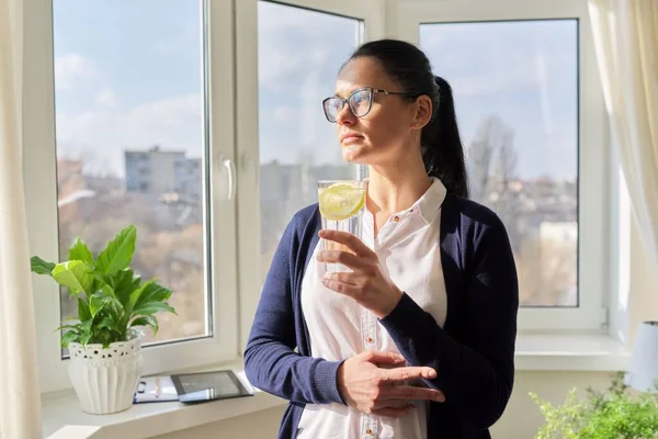 Zakelijke vrouw met glas water met citroen — Stockfoto