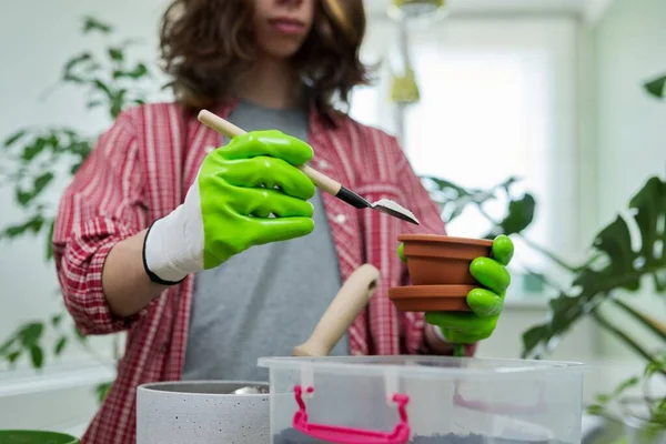 Подросток пересаживает комнатные растения, готовит почву перлитным вермикулитом — стоковое фото