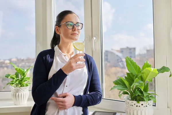 Affärskvinna med glas vatten med citron — Stockfoto