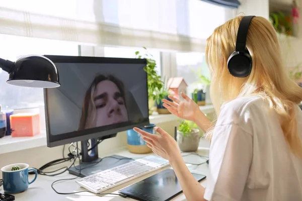 Dospívající žena ve sluchátkách mluvit online se svým přítelem teenager — Stock fotografie