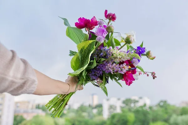 Närbild av ljusa bukett blommor i kvinnlig hand — Stockfoto