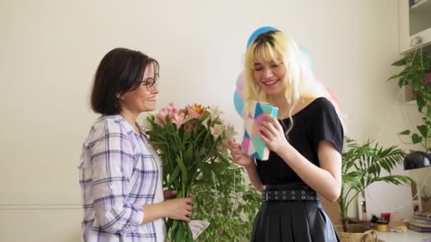 Maman félicitant fille avec bouquet de fleurs et boîte cadeau surprise — Video