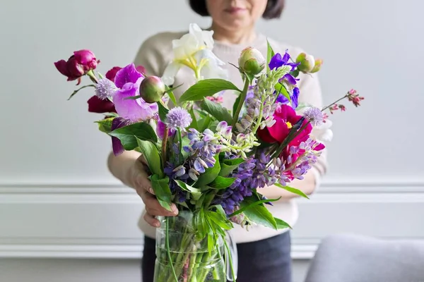 花菖蒲の明るい花の花束女性の手の中にlupinsクローズアップ — ストック写真