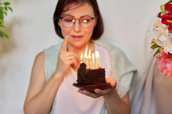 Madura hermosa mujer con pequeño pastel de cumpleaños con velas encendidas —  Fotos de Stock