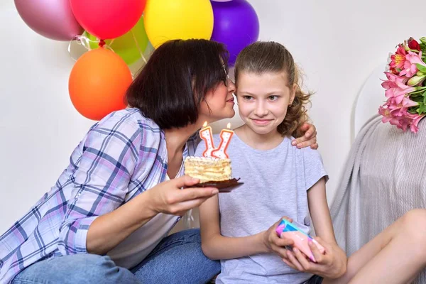 Mamá e hija con pastel de cumpleaños con velas, regalo, globos —  Fotos de Stock
