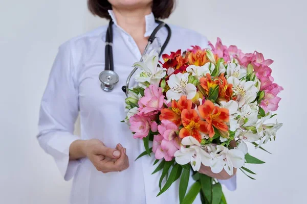 女性医師の手に花の花束のクローズアップ — ストック写真